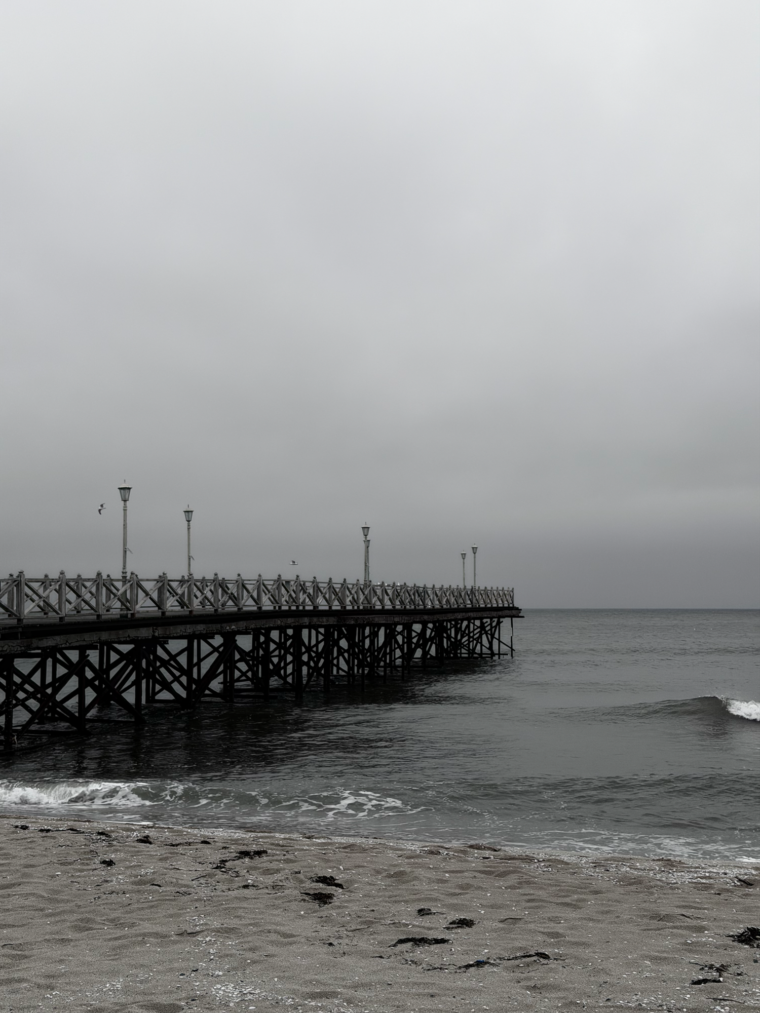 Black-and-white pier in Varna with sea and cloudy sky